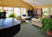 Thumbnail 5 of 42 - A living room with a couch, a chair, a coffee table, a television, and a bookshelf.