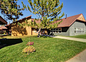 Thumbnail 1 of 42 - A house with a green lawn and a tree in front.