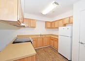 Thumbnail 28 of 42 - A kitchen with wooden cabinets and a white refrigerator.