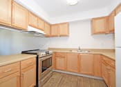 Thumbnail 24 of 42 - A kitchen with wooden cabinets and a black stove top oven.
