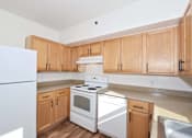 Thumbnail 25 of 29 - A kitchen with wooden cabinets and white appliances.