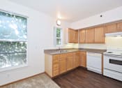 Thumbnail 26 of 29 - A kitchen with wooden cabinets and white appliances.