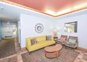 Thumbnail 7 of 29 - A living room with a yellow couch and a wooden coffee table.
