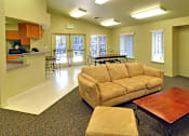 Thumbnail 10 of 30 - A living room with a couch, chairs, and a television.