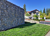 Thumbnail 1 of 30 - A stone wall in front of a house.