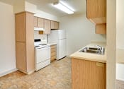 Thumbnail 15 of 17 - A kitchen with a refrigerator, sink, and oven.