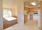 Thumbnail 16 of 17 - A kitchen with white appliances and wooden cabinets.