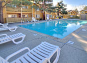 Thumbnail 9 of 17 - A pool surrounded by white lounge chairs.