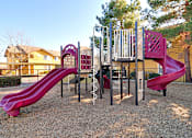 Thumbnail 3 of 17 - A playground with a red slide and a purple slide.