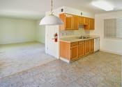 Thumbnail 38 of 41 - A kitchen with wooden cabinets and a tiled floor.