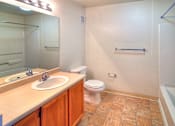 Thumbnail 36 of 41 - A bathroom with a toilet, sink, and shower.