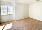 Thumbnail 41 of 41 - A room with a carpeted floor and a window with blinds.