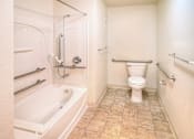 Thumbnail 35 of 41 - A white toilet in a bathroom with a tiled floor.