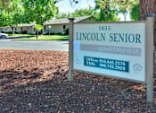 Thumbnail 4 of 35 - A sign for Lincoln Senior Apartments is displayed in front of a building.