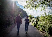 Thumbnail 2 of 76 - Two people walking down a path.