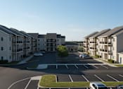 Thumbnail 8 of 11 - A parking lot in front of apartment buildings.