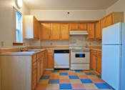 Thumbnail 14 of 29 - A kitchen with wooden cabinets and a checkered floor.