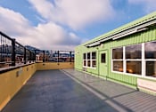 Thumbnail 12 of 29 - A green building with a balcony and a metal railing.