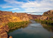 Thumbnail 1 of 76 - A bridge spans across a river in a canyon.