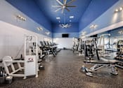 Thumbnail 9 of 25 - A gym with a variety of equipment including a rowing machine. at Infinity on the Landing Apartments , Euless, Texas