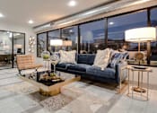 Thumbnail 13 of 25 - A modern living room with a blue couch and a coffee table at Infinity on the Landing Apartments, Euless
