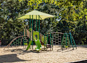 Thumbnail 17 of 74 - A playground with a green and yellow swing set and a yellow umbrella.