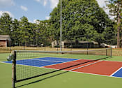 Thumbnail 20 of 74 - A tennis court with a net and a green pole.