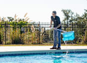 Thumbnail 4 of 37 - A man is pouring water into a pool.