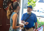 Thumbnail 6 of 37 - A man in a blue shirt is talking to a woman in a blue dress.