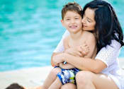 Thumbnail 16 of 37 - A woman is hugging a boy by the pool.