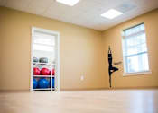 Thumbnail 19 of 37 - A yoga room with a shelf of exercise balls and a yoga mat on the wall.
