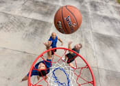 Thumbnail 21 of 37 - A basketball is in mid-air as it approaches two players who are reaching for it.