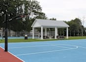 Thumbnail 22 of 37 - A basketball court with a basketball hoop and a pavilion in the background.