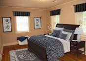 Thumbnail 32 of 37 - A bedroom with a bed, nightstand, and two framed pictures on the wall.