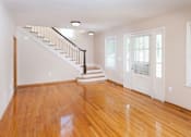 Thumbnail 34 of 37 - A room with wooden floors and a staircase.