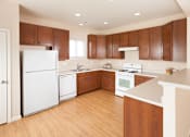Thumbnail 36 of 37 - A kitchen with wooden cabinets and white appliances.