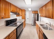 Thumbnail 37 of 37 - A kitchen with wooden cabinets and a stainless steel refrigerator.