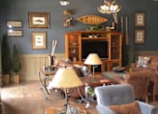 Thumbnail 25 of 74 - A living room with a grey armchair and a yellow lamp.