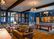 Thumbnail 27 of 74 - A living room with a pool table and a couch.