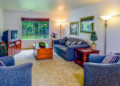Thumbnail 71 of 74 - A living room with a couch, chairs, and a television.