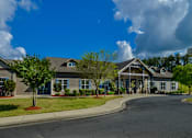 Thumbnail 47 of 74 - A large building with a grey roof and a tree in front of it.