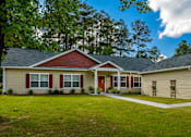 Thumbnail 57 of 74 - A two-story house with a red roof and a garage door.