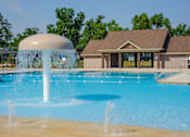 Thumbnail 5 of 21 - A large pool with a waterfall feature in front of a building.