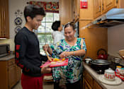 Thumbnail 11 of 21 - A woman and a boy are preparing food in a kitchen.