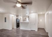 Thumbnail 16 of 21 - A spacious room with a ceiling fan and a wooden floor.
