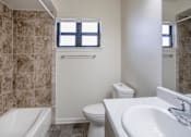 Thumbnail 15 of 21 - A bathroom with a toilet, sink, and tub.