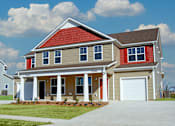 Thumbnail 20 of 21 - A two-story house with a red roof and a garage.