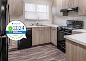Thumbnail 18 of 21 - A kitchen with a black fridge and a stove top oven.