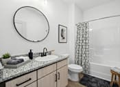 Thumbnail 15 of 69 - A bathroom with a sink, mirror, toilet, and shower.