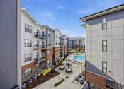 Thumbnail 61 of 69 - Apartment complex with a pool and landscaping.